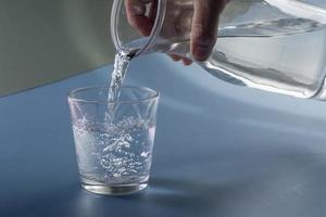 detalle de persona relleno vaso de agua. hidratación concepto foto