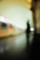 Motion blur image of a subway platform with human silhouettes. photo