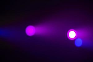 Pink beams of light from stage spotlights on a dark blue background. Stage illumination. photo