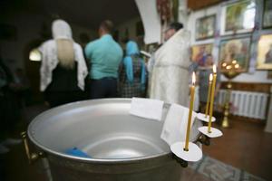 Blurred Orthodox on the background of the font for the baptism of the baby. photo