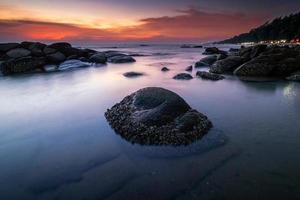 playa y rocas a puesta de sol foto