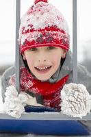 Portrait of a boy in a red winter hat covered with snow. photo