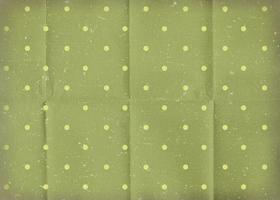 Vintage green crumpled paper with white polka dots. Old worn paper wallpaper with cracks. photo