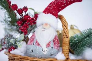 Christmas decoration gnome in spruce branches in a wicker basket. photo