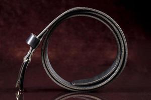 Black leather belt on a dark background. Leather products. photo