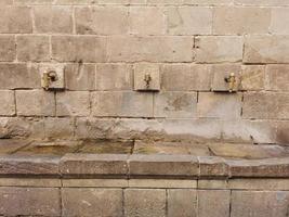 Street taps with drinking water on a stone wall, stone sink photo