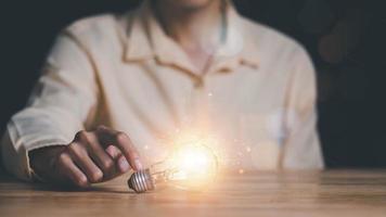 man pointing light bulb ,solution concept and demonstrating leadership strategies ,looking for new ideas ,positive thinking ,inspiration and creativity ,innovation and brain power from brainstorming photo