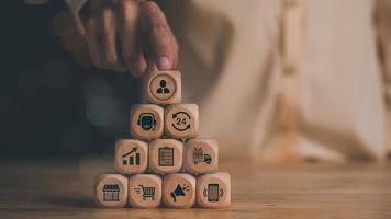 Human hand pointing at a wooden block ,asking help through call center ,customer support service concept ,call center ,consulting team to help customers solve urgent problems ,after sales service photo