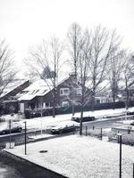 Snow-covered street with houses in the background photo