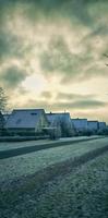 Winter landscape with snow covered houses and trees in the countryside in Germany. photo