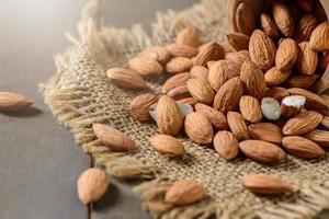 Almendras nuez en madera antecedentes. ellos son muy nutritivo y Rico en sano grasas foto