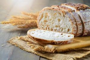 Sliced Sourdough Bread on wood board on wood background, homemade bakery photo