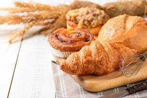 mantequilla cuerno con de masa fermentada y danés Pastelería en blanco madera fondo, foto