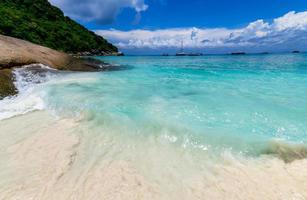 movimiento de multa blanco arena con claro mar con blanco nublado y azul cielo a similán isla, foto