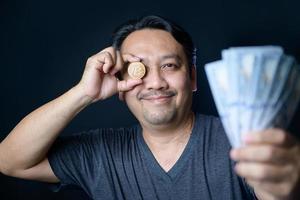 Happy Middle man holding bitcoin and US dollar on black background. Ideas for investing and trading cryptocurrency or bitcoin photo