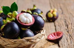 Fresh Mangosteen in bamboo basket and on old wood baclground. Queen of Fruits, asia fruits concept photo