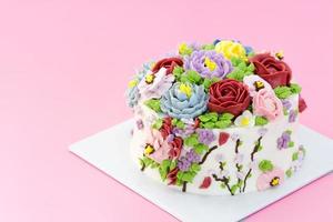 Homemade cake decorated with beautiful flowers on pink background, photo