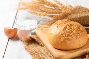 Sourdough Bread with Sesame on wood plated and Whisk, flour and eggshells photo
