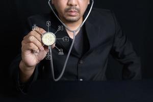 Doctor holding stethoscope and virtual screen with Emergency line icons photo