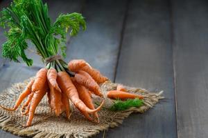 Fresco bebé zanahorias en madera fondo, alto beta caroteno foto