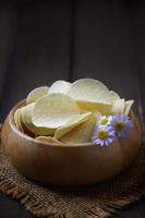 Potato chips bowl on  wood background, fat food or junk food photo