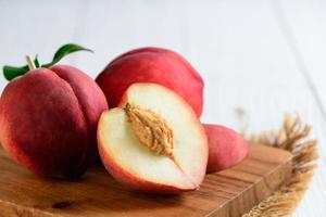 Fresh  peaches on wood plate and white background. Peaches are widely eaten fresh photo