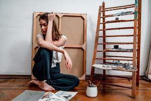 portrait of a beautiful young artist, draws pictures in the workshop photo