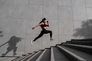 ajuste joven mujer saltando y corriendo foto