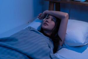 Stressed person. Asleep, sleep asian young woman, girl under blanket, suffering from insomnia, awake at night in bedroom, tired and exhausted. Frustrated people with problem, exhausted on nightmares. photo