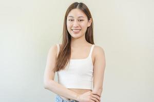 Smiling positive, attractive asian young woman wearing casual dress, portrait of beautiful brunette her with long brown hair, feeling happy looking to camera standing isolated on white background. photo