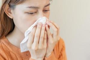 Sick, Coronavirus covid asian young woman, girl have a fever, flu, hand in use tissues paper sneezing nose, runny and cough, standing on isolated background. Health care to disease influenza seasonal photo