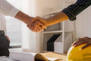 Successful team building asian young male, man or builder group handshake together at office after home project done, good deal. Happy business people, Worker meeting, shaking hands and success. photo