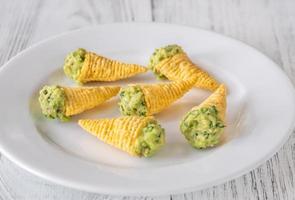 Tortilla chips cones with guacamole photo