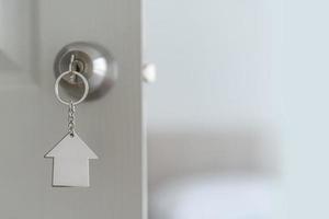 Close up of key on the door, Open door to a new home with key, property and new home concept photo