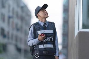 Male security guard using portable radio photo