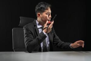 Security guard using portable radio transmitter in control room photo