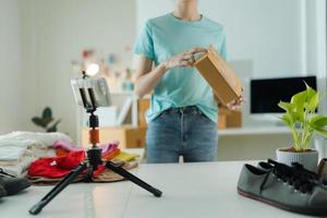 A young woman owner of a small e-commerce business is packing items into the mail box. photo