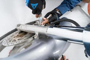 People are repairing a motorcycle Use a wrench and a screwdriver to work photo