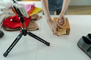 un joven mujer propietario de un pequeño comercio electrónico negocio es embalaje artículos dentro el correo caja. foto