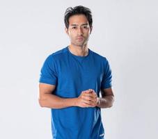 Elegant young man in blue shirt standing on white background photo