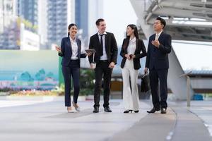 Business people walking and talk to each other in front of modern office photo