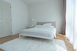 White bedroom with white curtains and white pillows photo