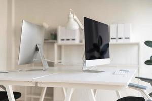 White table and chair with computer monitor and modern file cabinet in white home office photo