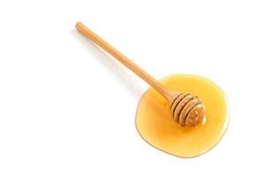 Honey with honey dipper on white background photo