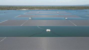 aéreo parte superior ver de solar paneles o solar células en boya flotante en lago mar o océano. video