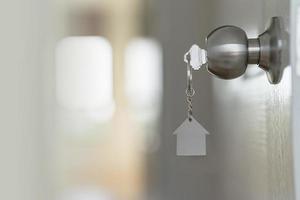 Close up of key on the door, Open door to a new home with key, property and new home concept photo