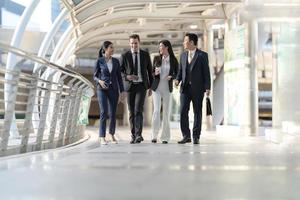 Business people walking and talk to each other in front of modern office photo