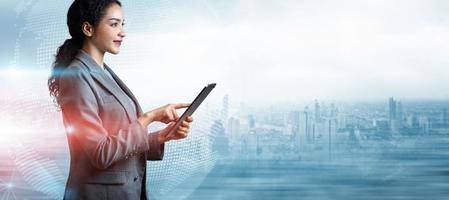 Businesswoman using tablet on world map city background with copy space, Business innovation technology digital concept, Double exposure of futuristic global network interface, Programming, IT support photo