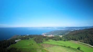 panoramisch visie van groen weide, Woud, blauw lucht, en oceaan. - antenne video