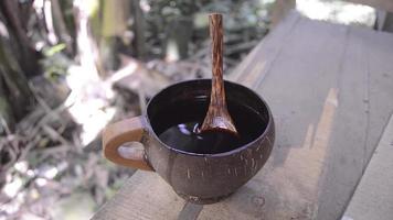 dichtbij omhoog koffie in kop met hout en natuur achtergrond video